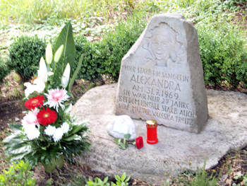 Blumen und Kerze am Gedenkstein